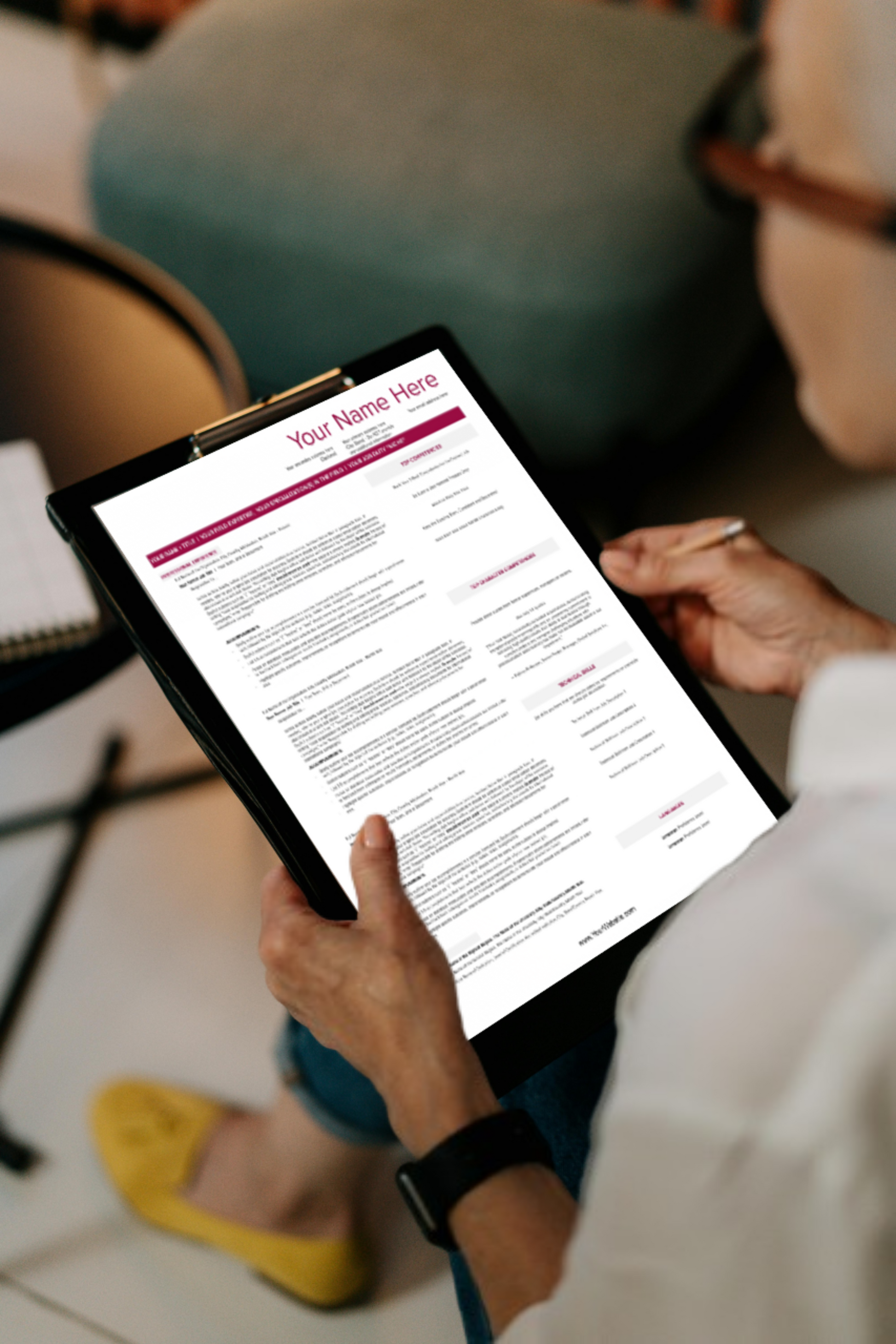 A close up of a woman holding a clipboard with a resume upon it.